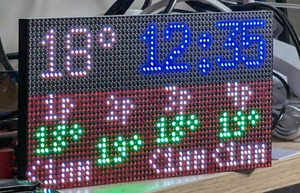 A panel of LEDs, displaying 18 degrees in the top-left, 12:35 in the top-right, and a table of with four hourly columns 1pm, 2pm, 3pm, 4pm, and the temperatures 18 deg, 19 deg, 18 deg, 19 deg under the hour columns.